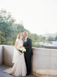 bride and groom kiss on balcony