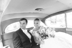 Bride and groom in back of car
