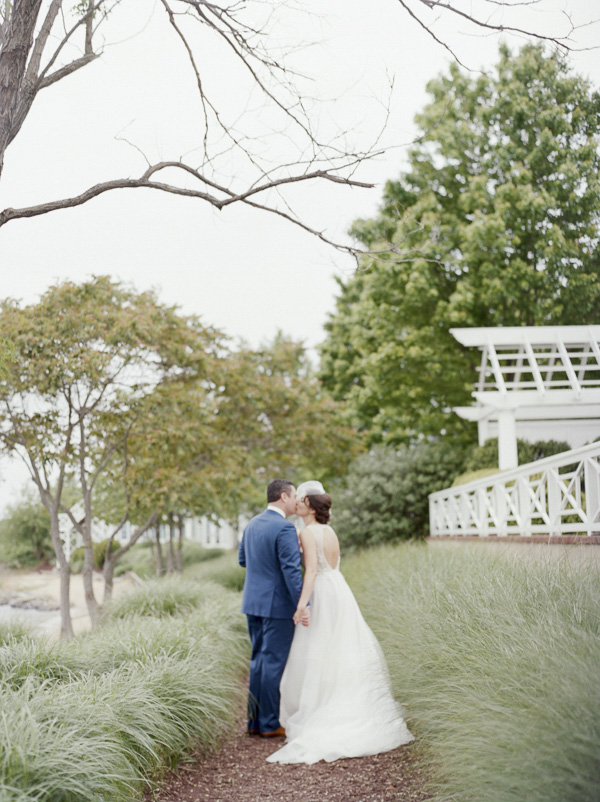 bride and groom kiss on path