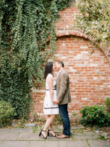 couple kissing by brick wall