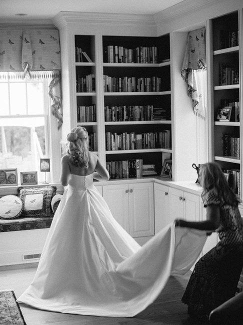 Mother of bride fixing back of brides dress