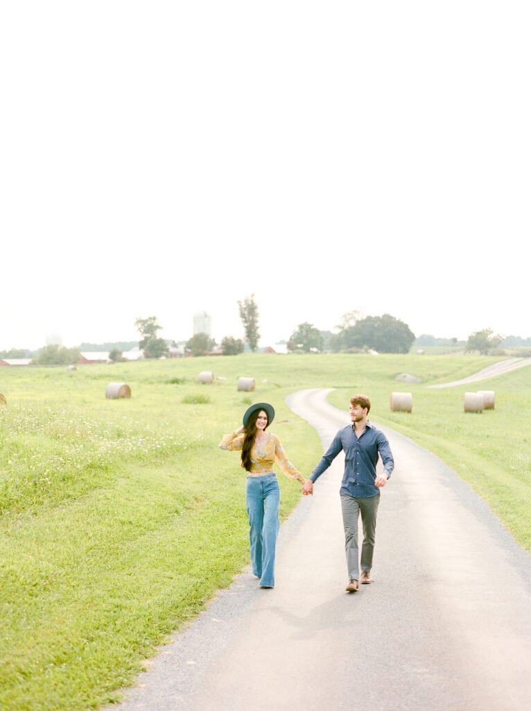 couple holding hands walking down road
