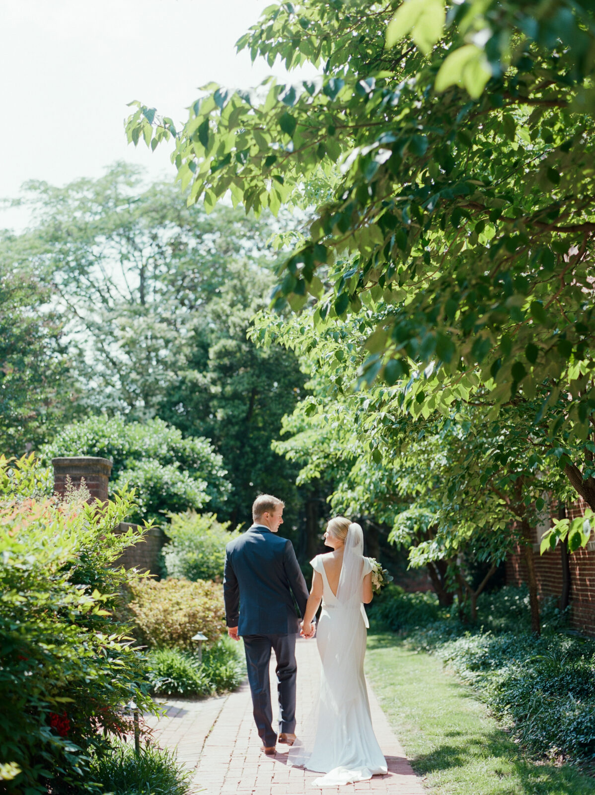 bride and groom walking in green garden area