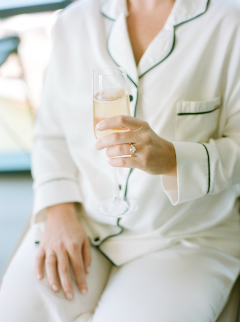 bride in pajamas holding champagne