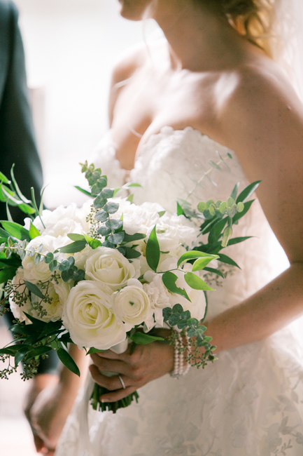bride holding green and cream bouquet
