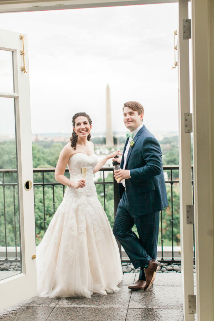 Bride and groom on balcony with washington DC monument in background, taken by astrid photo